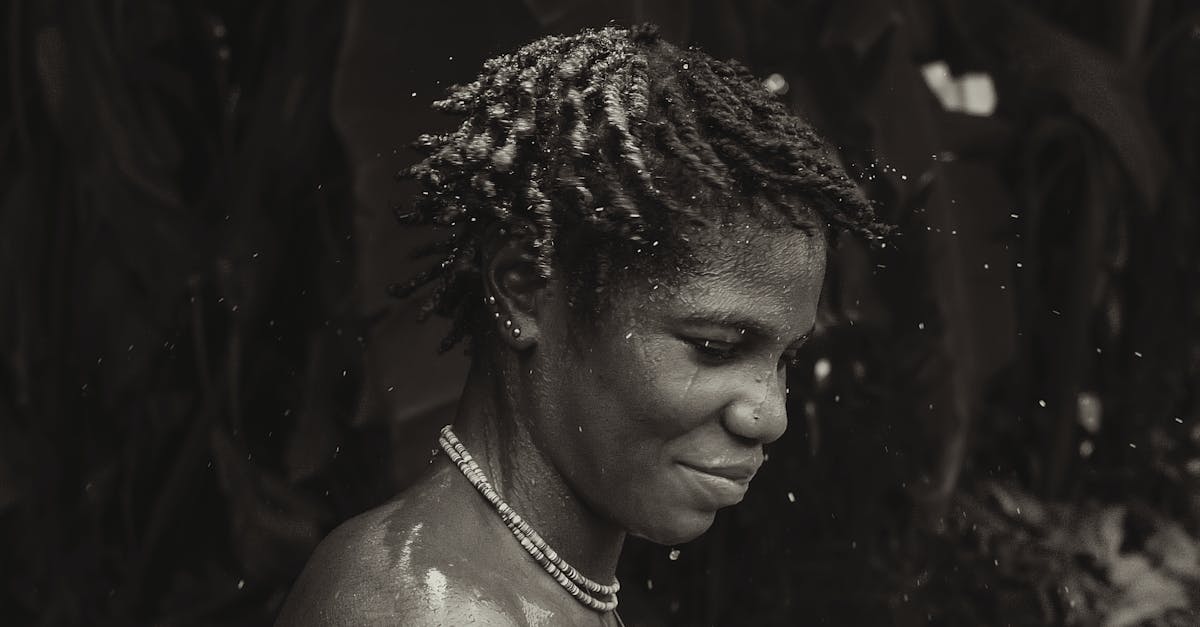 Captivating black and white portrait of a woman with water splashes and a serene expression.