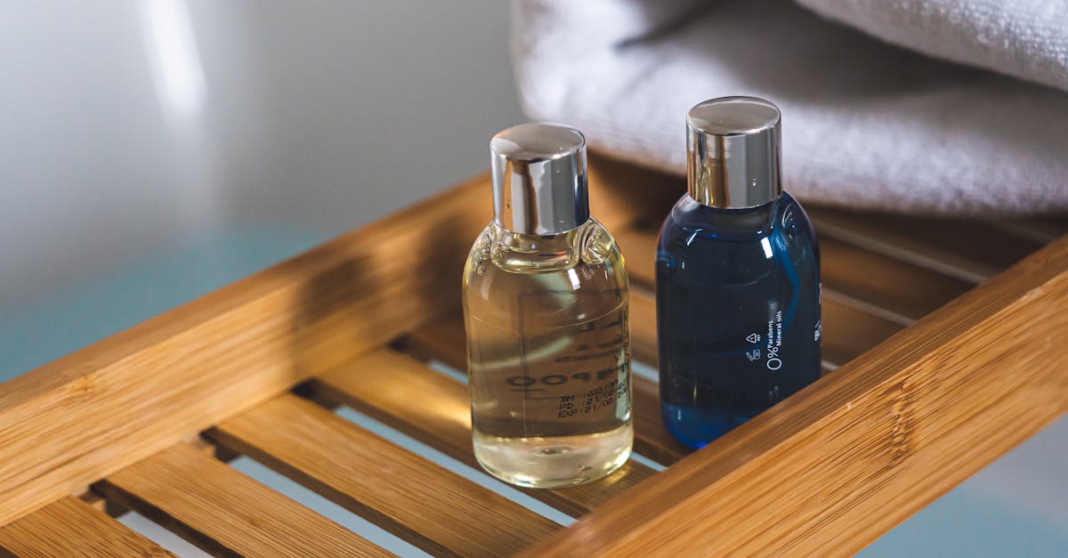 Two elegant toiletries bottles on a bamboo tray in a serene bathroom setting.