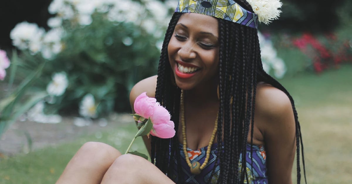 A joyful woman in a patterned dress enjoys a sunny day outdoors in London.
